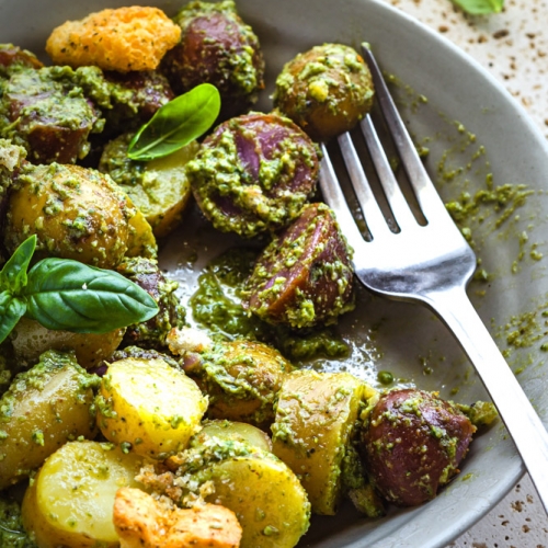 Pesto Potato Salad in a grey plate with basil topping