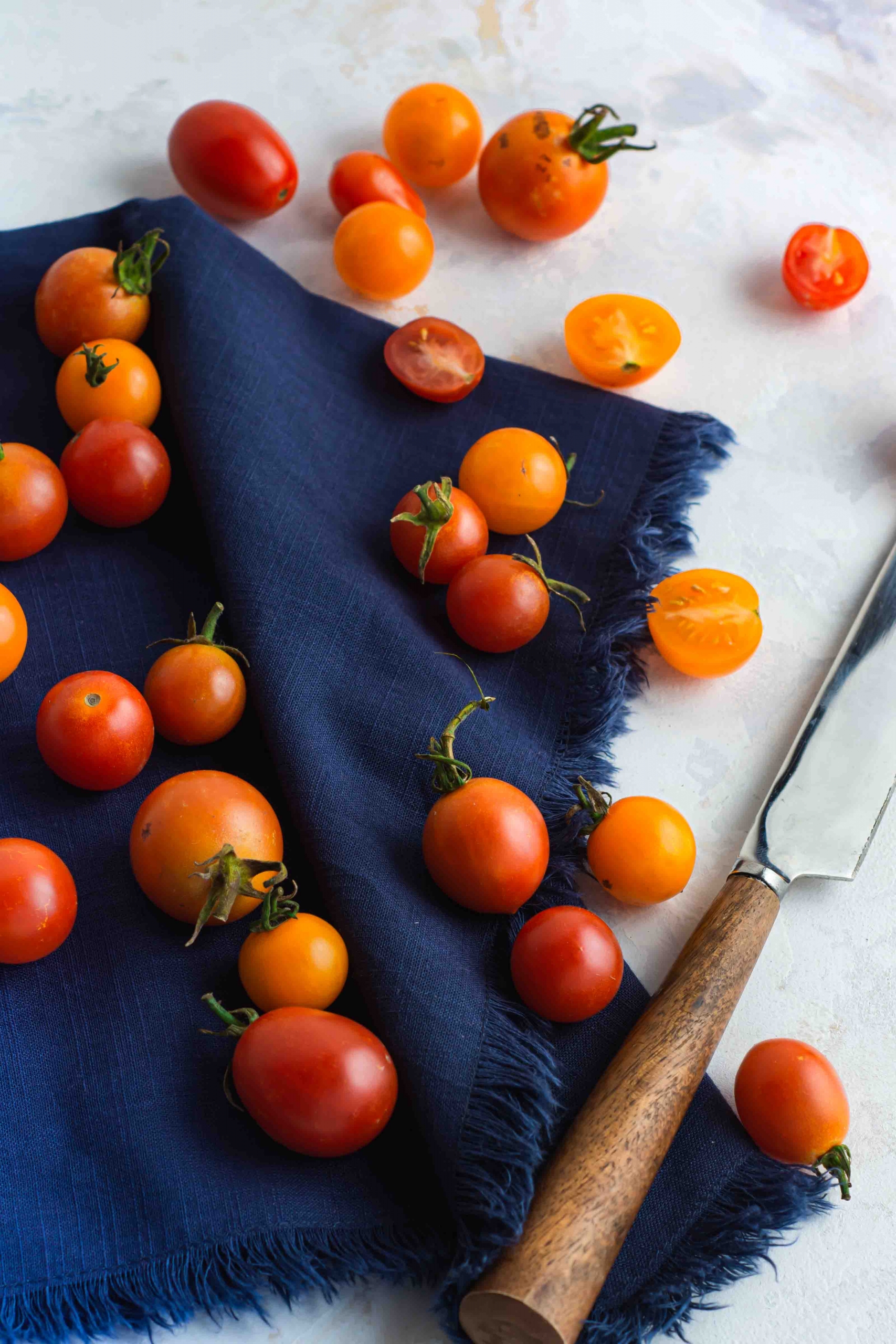 Cherry Tomatoes on a blue napkin with a knife