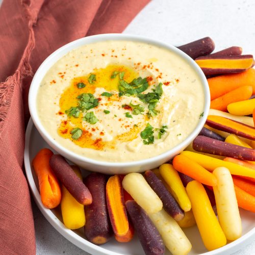 hummus in a plate with baby carrots