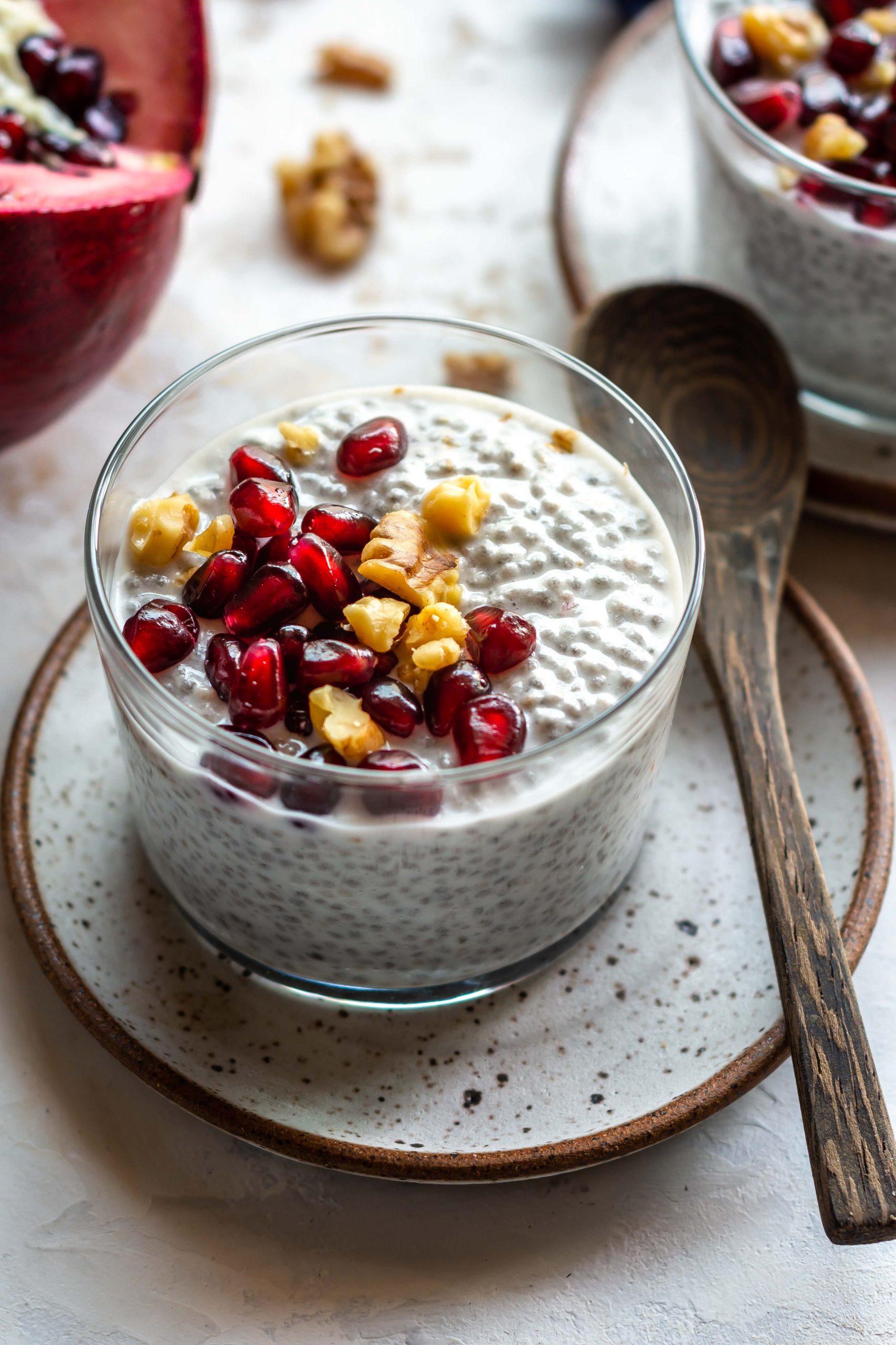 coconut chia pudding in a glass bowl with pomegranate seeds on top