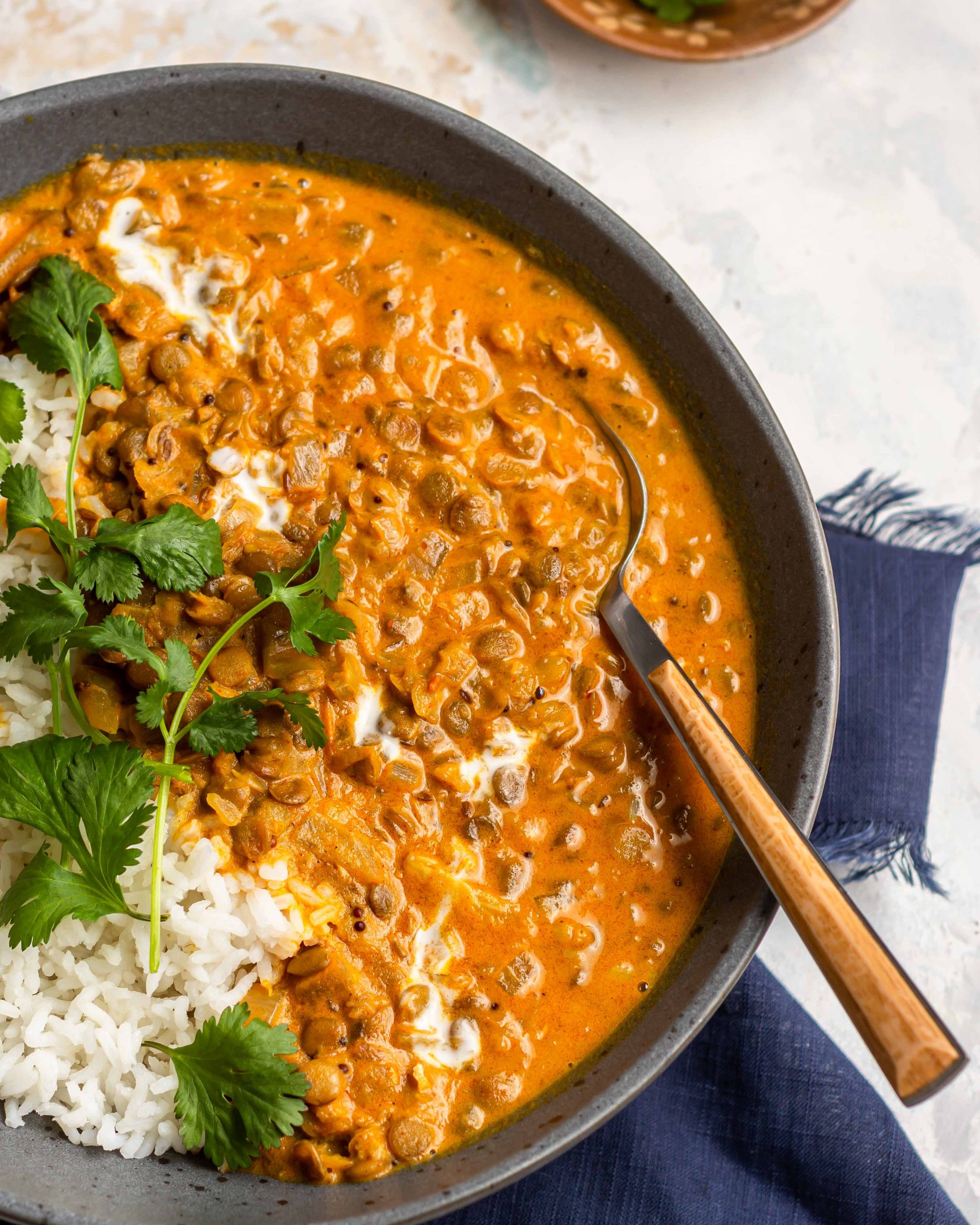 coconut lentil curry served with cooked white rice and fresh cilantro