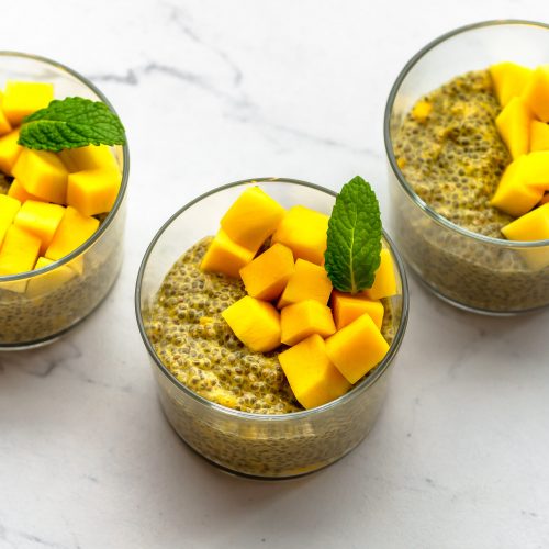 three cups of mango chia pudding with chopped mango as topping