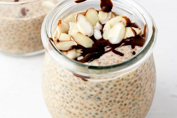 almond butter chia pudding in a jar with melted chocolate and raw almond slices